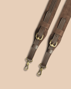 Brown leather strap with gold hardware on a beige background