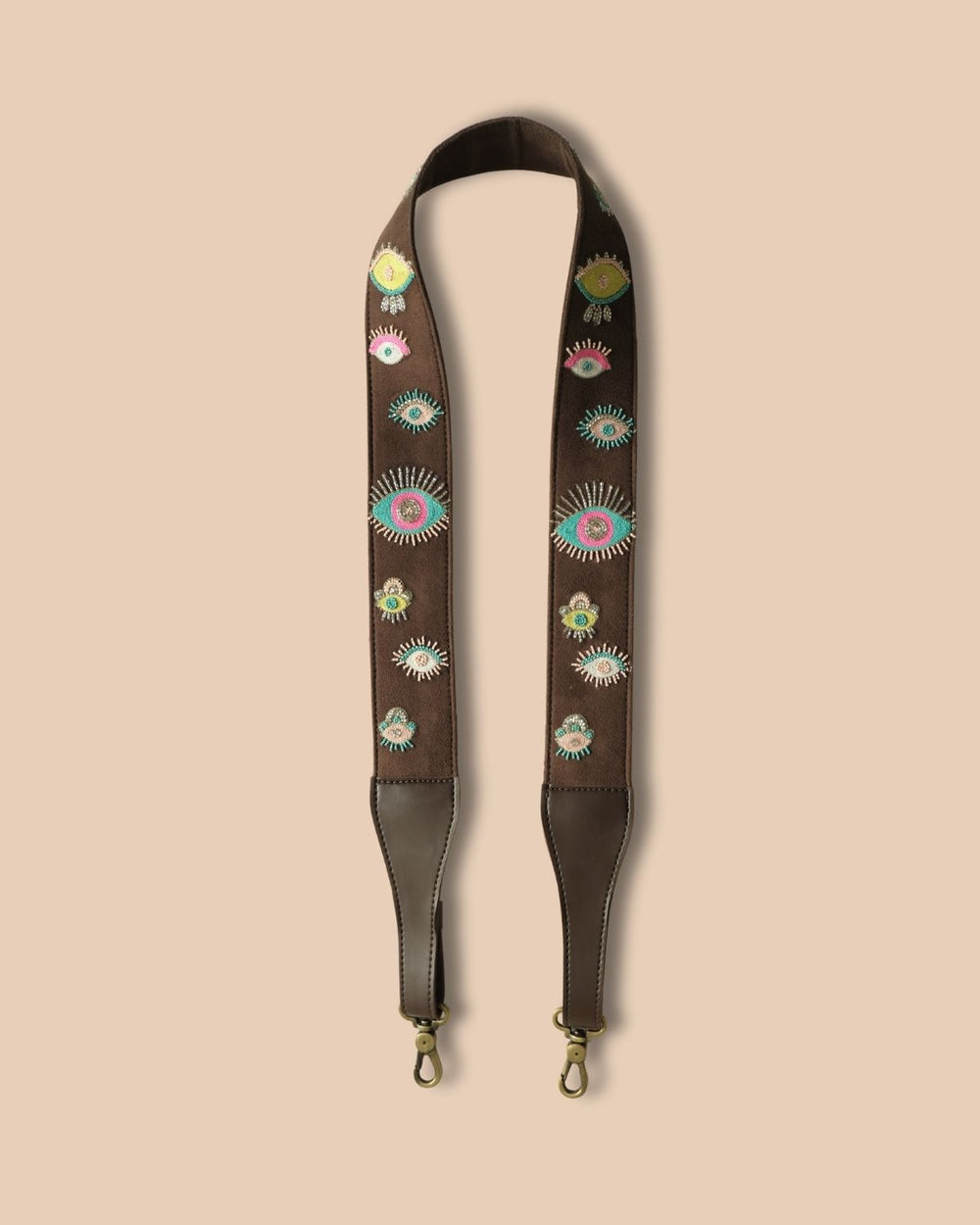 Brown leather strap with floral embroidery on a beige background