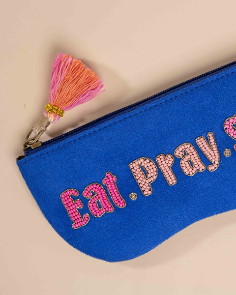 Blue pouch with 'Eat. Pray. Love.' text and pink tassel 