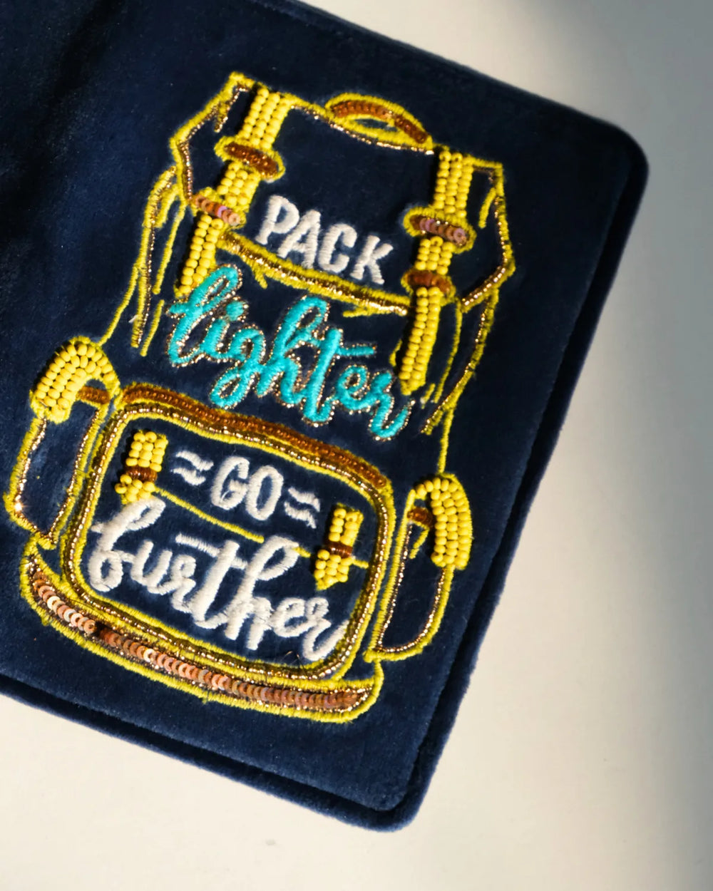 Embroidered patch with a backpack design and text on a blue background