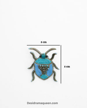 Embroidered beetle brooch in shades of blue with bead details