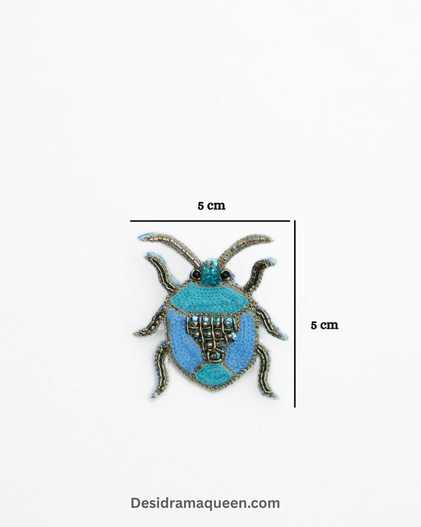 Embroidered beetle brooch in shades of blue with bead details