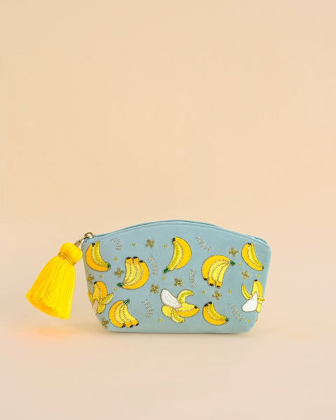 Blue makeup pouch with embroidered banana designs and yellow tassel zipper, handmade cosmetic bag for travel and daily use.