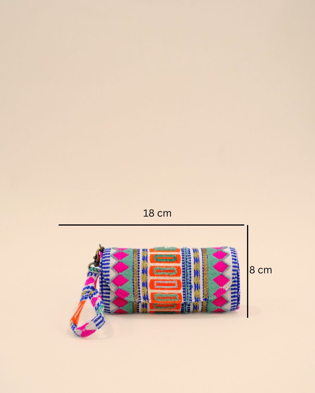 Text: Cylindrical sunglass cover with a wrist strap, featuring vibrant bohemian embroidery in pink, orange, blue, and green geometric patterns for a bold and stylish look.