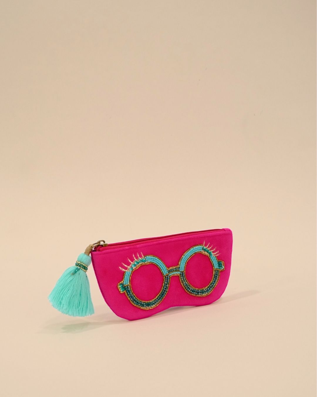 Vibrant hot pink sunglass cover with round beaded spectacle embroidery and turquoise tassel zipper, stylish handmade pouch for travel accessories.