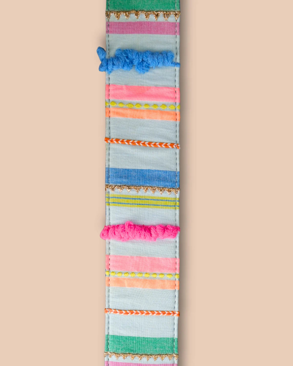 Multicolored striped bag strap on a beige background