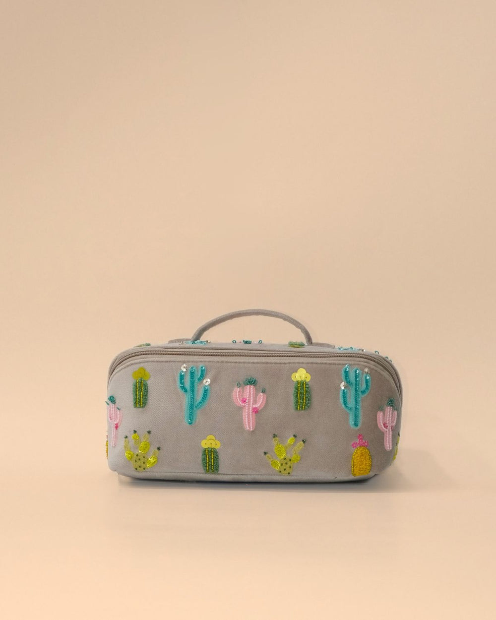 Front view of the Cactus Sand Shell Makeup Pouch featuring colorful embroidered cactus motifs on light grey fabric with a zip closure, top handle, and spacious design for cosmetics and travel essentials.
