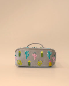 Front view of the Cactus Sand Shell Makeup Pouch featuring colorful embroidered cactus motifs on light grey fabric with a zip closure, top handle, and spacious design for cosmetics and travel essentials.