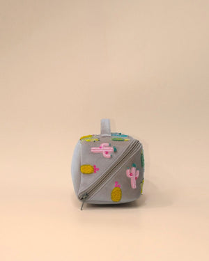 Side profile of the Cactus Sand Shell Makeup Pouch showcasing colorful cactus embroidery, structured construction, durable zipper closure, and spacious storage for makeup and toiletries.