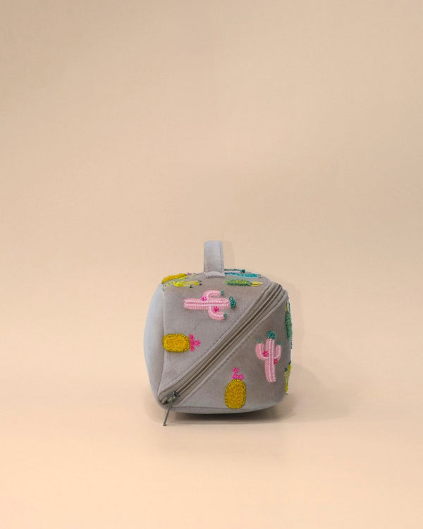 Side profile of the Cactus Sand Shell Makeup Pouch showcasing colorful cactus embroidery, structured construction, durable zipper closure, and spacious storage for makeup and toiletries.