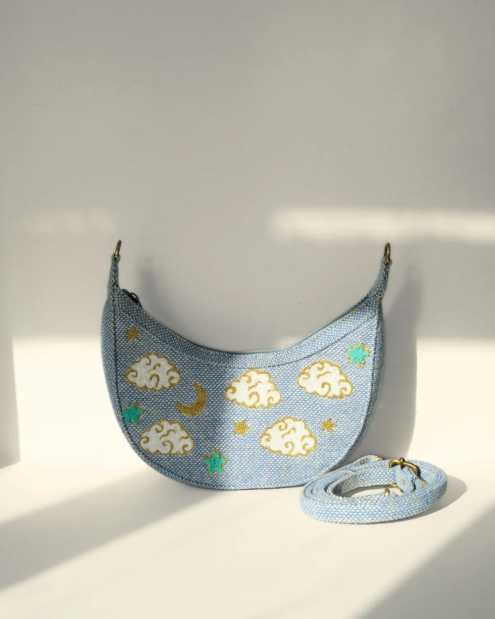 Light blue pet carrier with cloud and moon designs on a white background