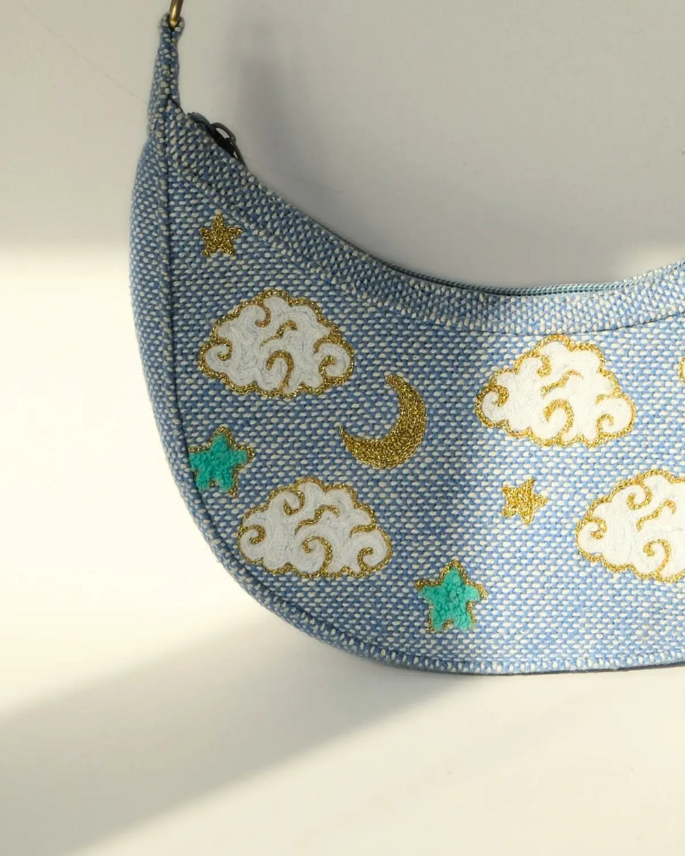 Light blue pet carrier with cloud and moon designs on a white background