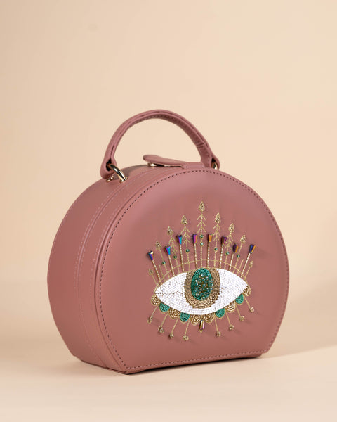 Peach sling bag with crystal-enhanced embroidery, evil eye design, and hand beadwork