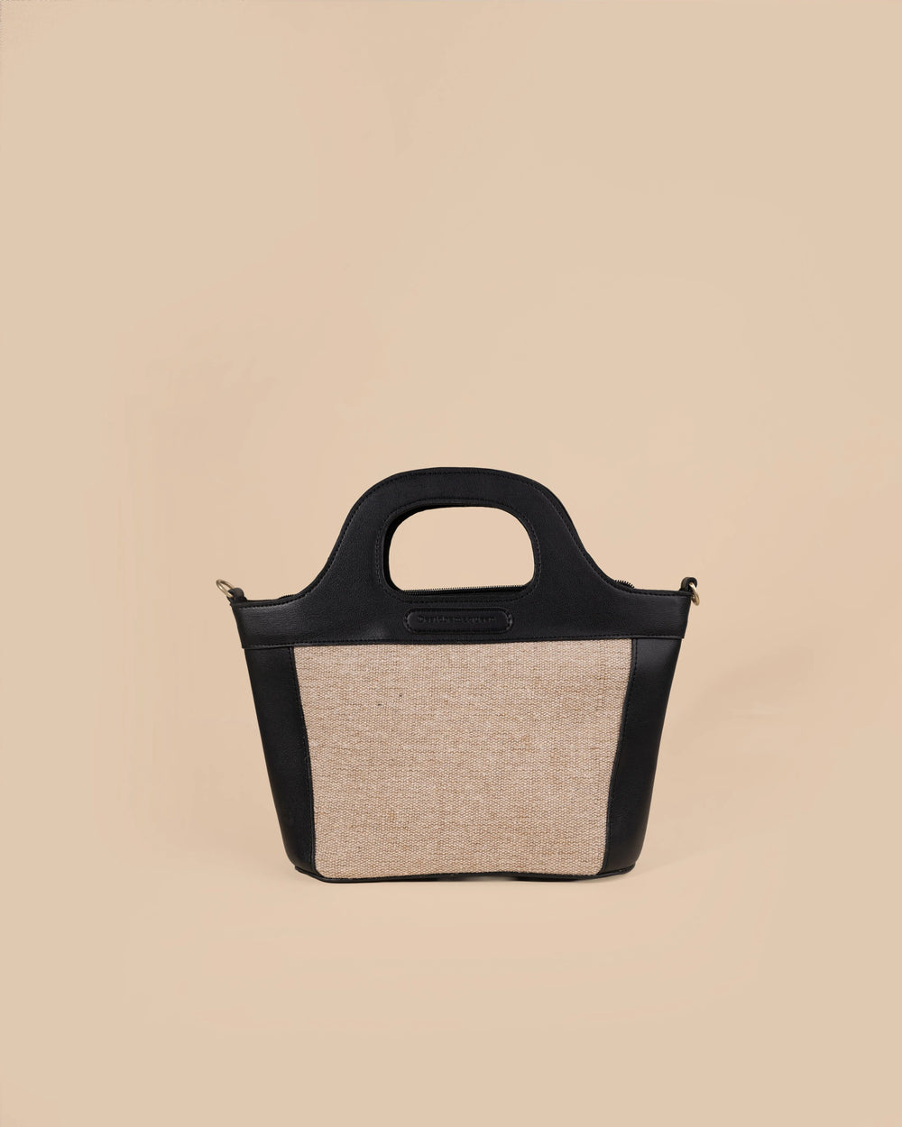 Black handbag with floral design on a beige background