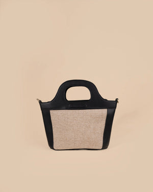 Handbag with black leather top handle and natural fabric body on beige background
