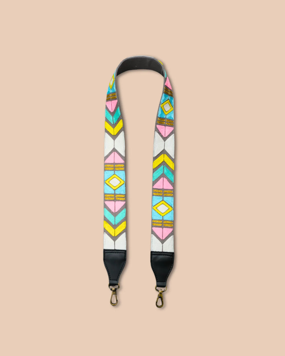 Colorful geometric patterned strap with black ends on a beige background