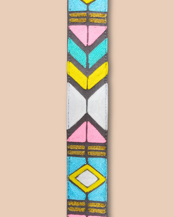 Colorful geometric patterned strap with black ends on a beige background