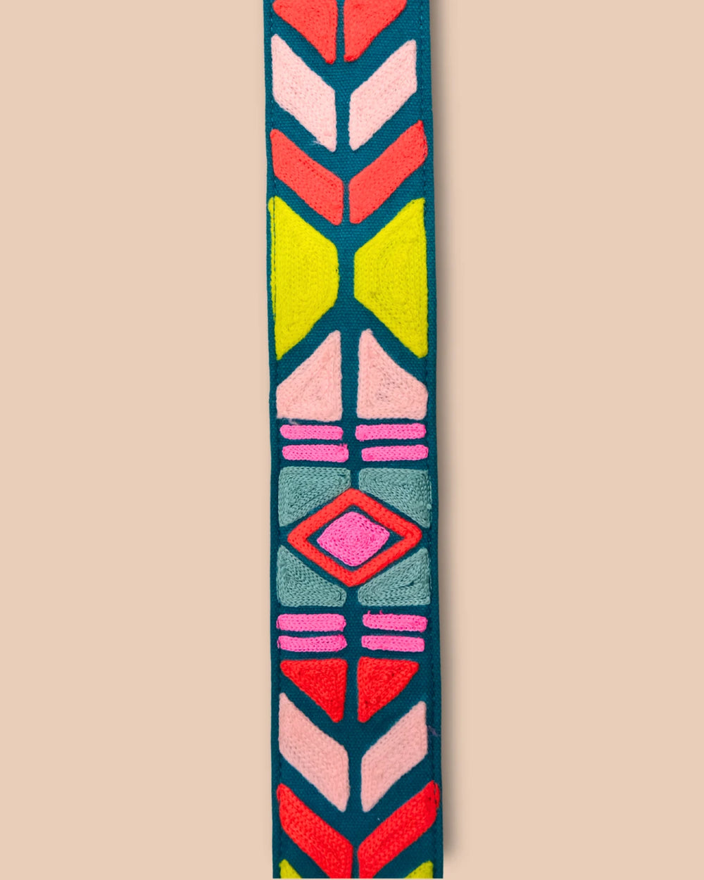Colorful patterned strap with brown accents on a beige background