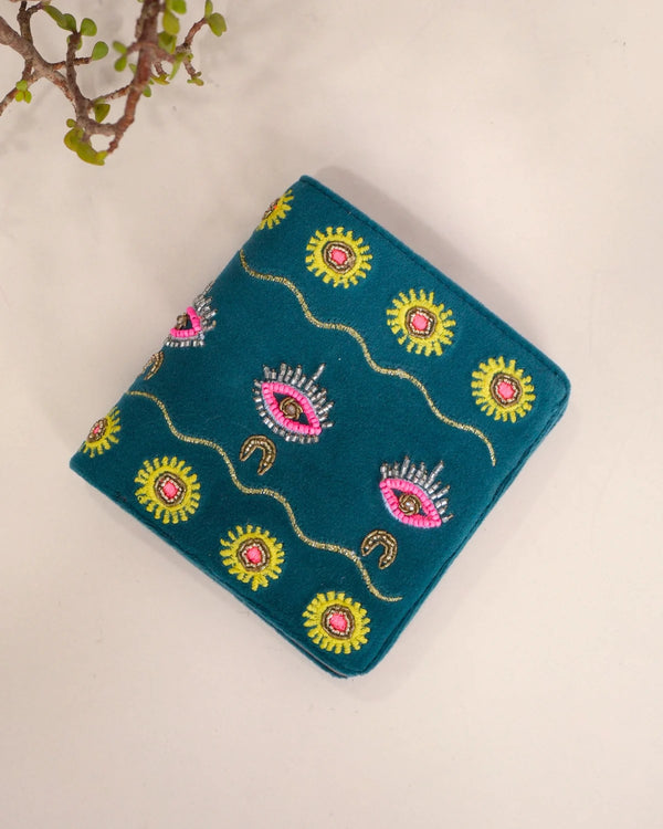 Blue embroidered fabric with colorful patterns on a beige background