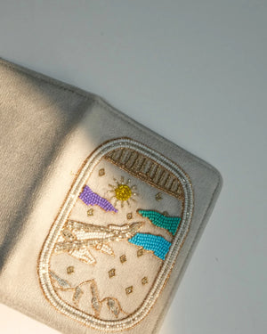 Embroidered patch on a beige fabric with a snowman design.