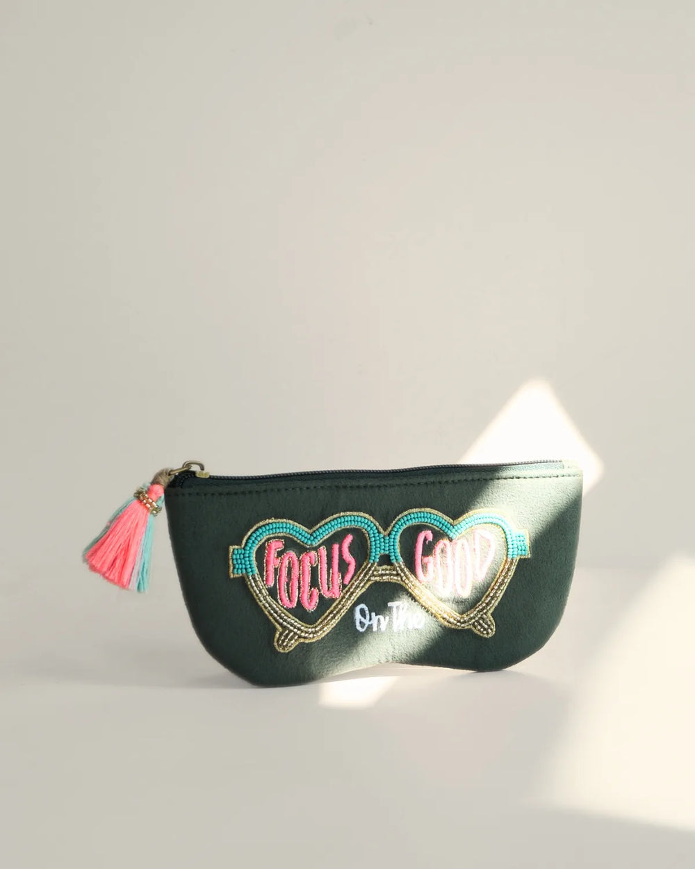 Black pouch with heart-shaped glasses design and 'Focus on Good' text on a light gray background