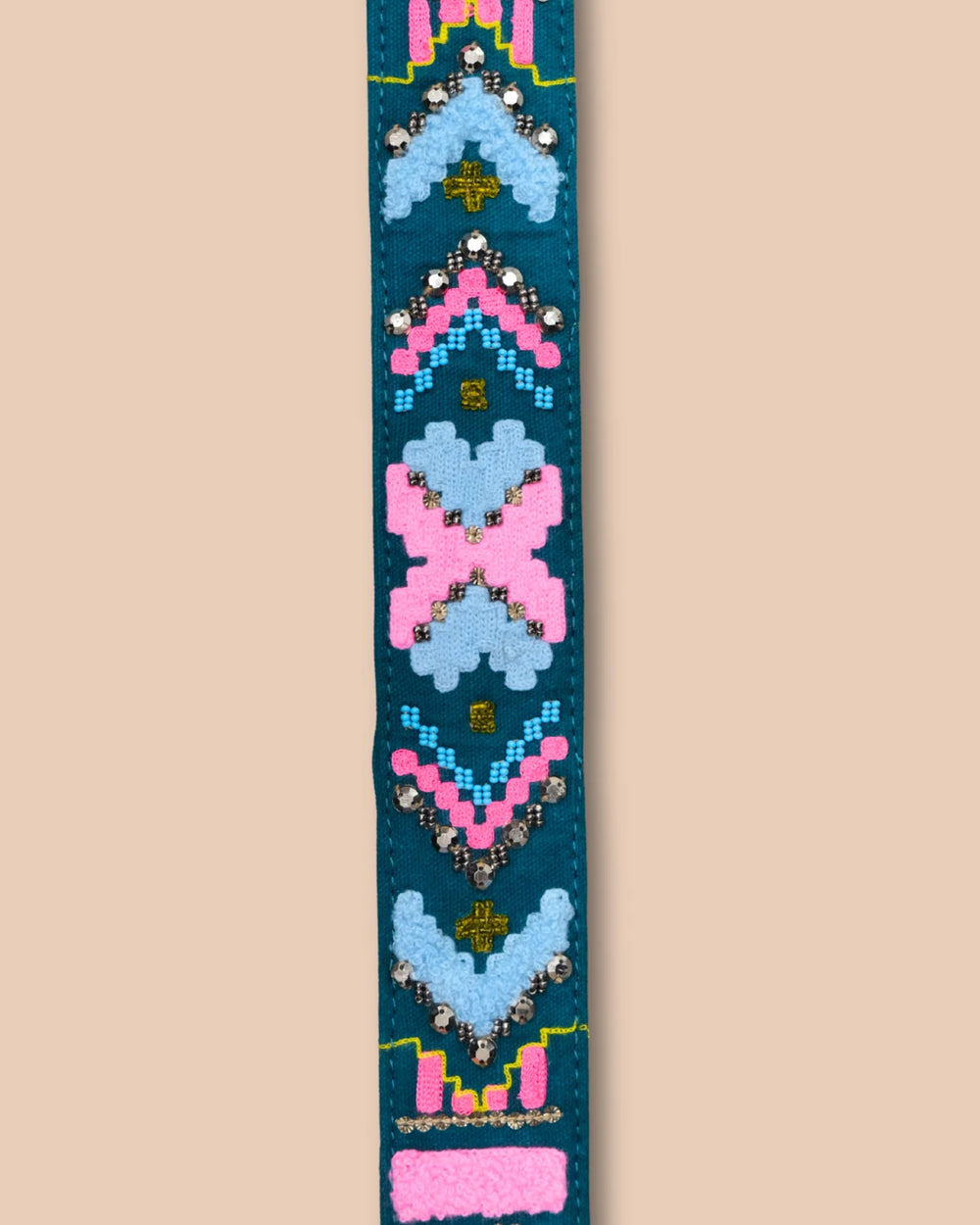 Decorative bag strap with colorful pattern on a beige background