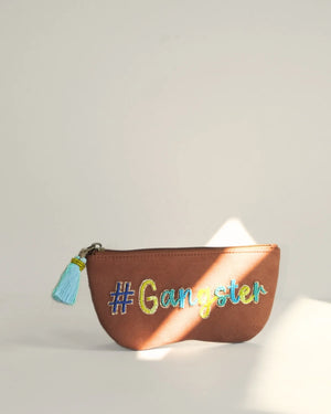 Brown pouch with '#Gangster' text and tassel on a light background