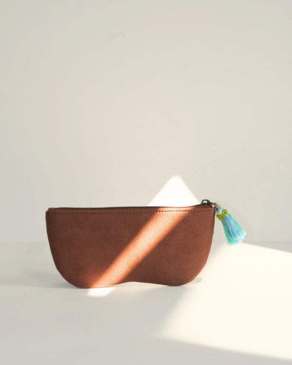 Brown leather pouch with a tassel on a light background
