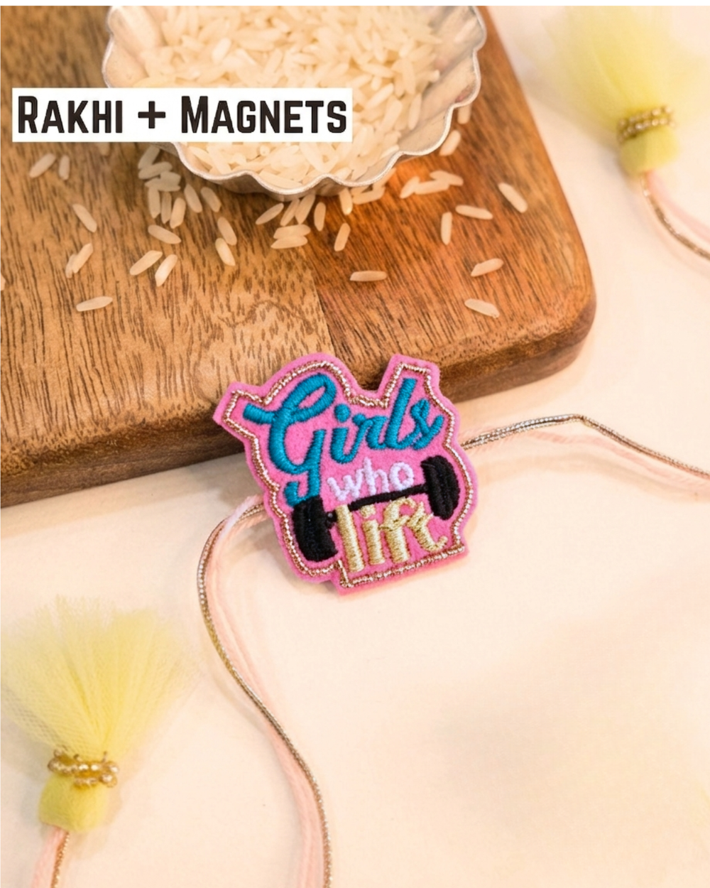 Girls Who Lift embroidered rakhi magnet placed beside a bowl of rice, styled for a festive Raksha Bandhan celebration.