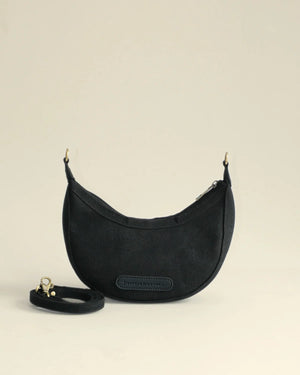 Black handbag with a strap on a beige background