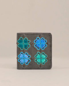 Small wallet with blue and green floral patterns on a beige background
