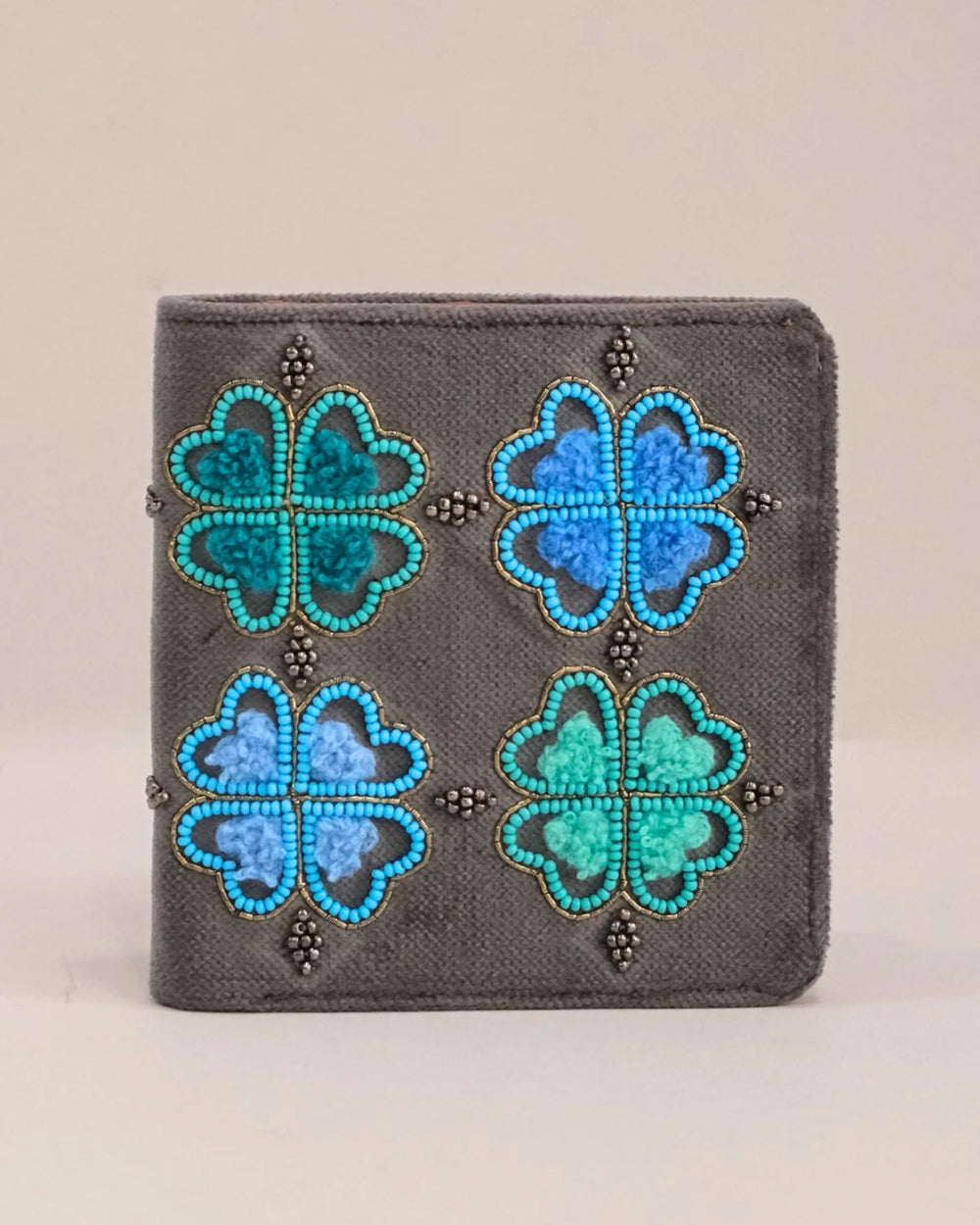 Small wallet with blue and green floral patterns on a beige background