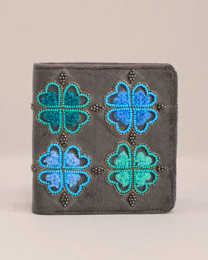 Gray wallet with blue and green floral patterns on a beige background