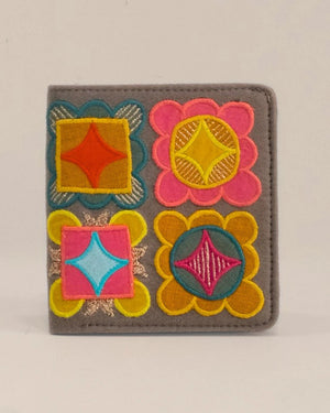 Colorful embroidered wallet with geometric patterns on a gray background