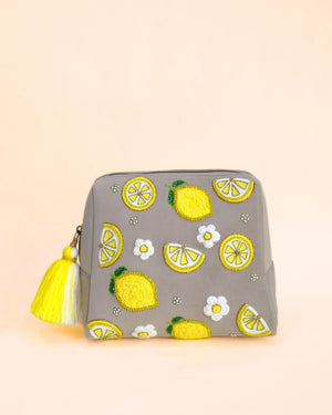 Grey makeup pouch with embroidered lemon motifs, white floral details, and yellow tassel zipper, handmade cosmetic bag.