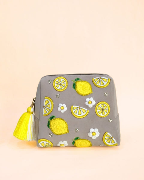 Grey makeup pouch with embroidered lemon motifs, white floral details, and yellow tassel zipper, handmade cosmetic bag.