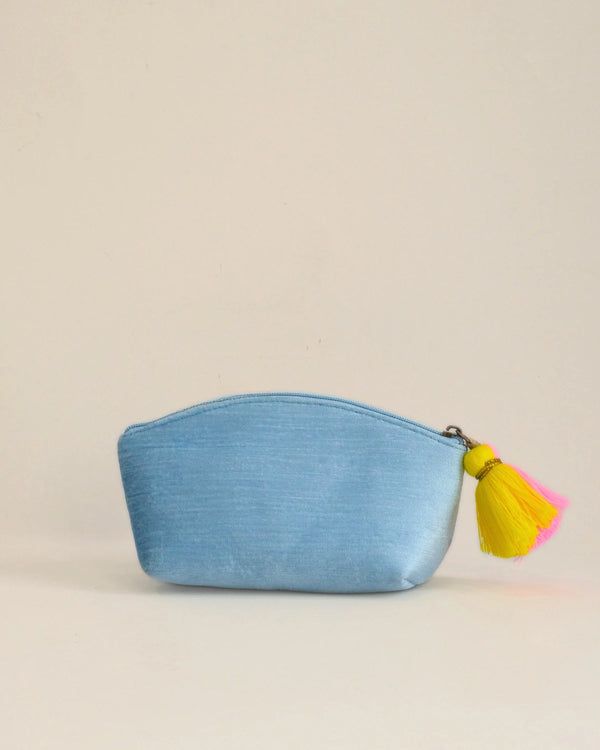 Blue pouch with colorful tassel on a beige background