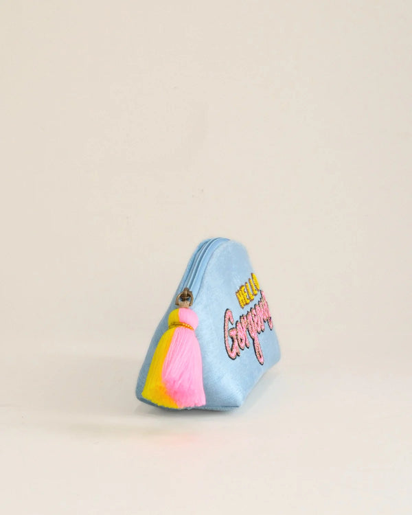 Small blue pouch with colorful accents and text on a beige background