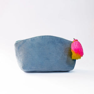Blue denim pouch with a pink and yellow tassel on a white background