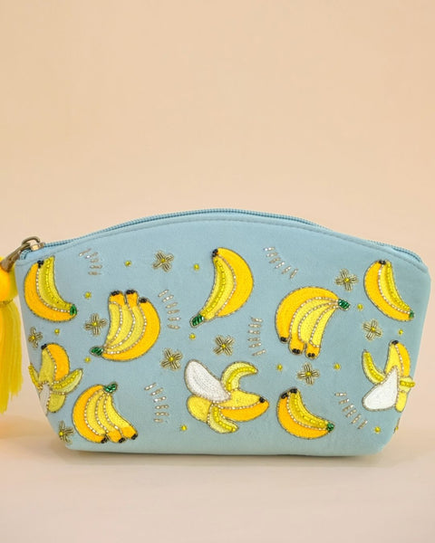 Pastel blue pouch featuring embroidered banana motifs with beads and tassel zipper, handmade makeup bag for accessories and toiletries.