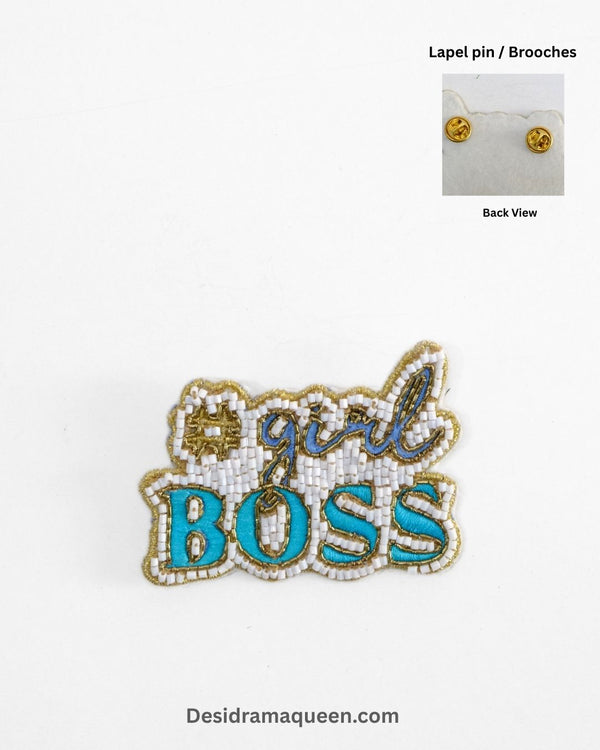 Handmade beaded brooch with #GirlBoss design in gold embroidery and turquoise lettering.