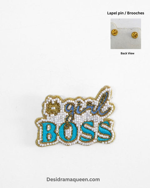 Handmade beaded brooch with #GirlBoss design in gold embroidery and turquoise lettering.