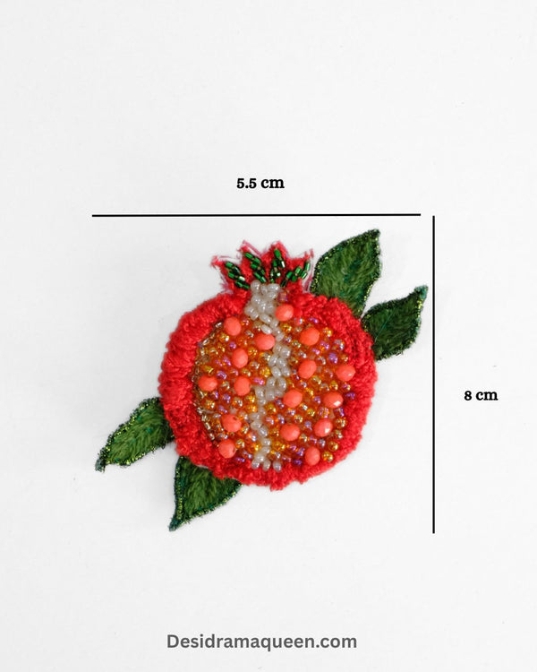 Vibrant red pomegranate brooch with green leaf and bead detailing, handmade fruit lapel pin for jackets, scarves, and bags