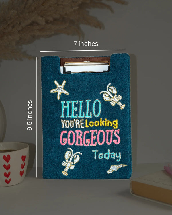 Blue clipboard with decorative text and measurements on a neutral background
