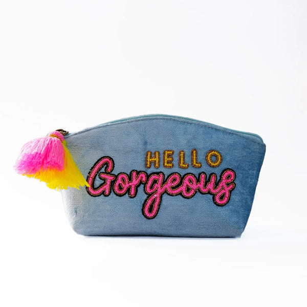 Denim pouch with 'Hello Gorgeous' embroidery and colorful tassels on a white background