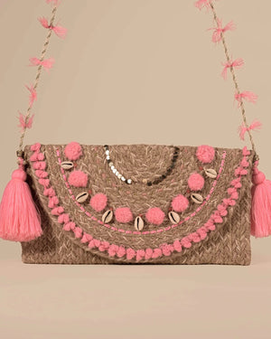 Handbag with pink pom-poms and tassels on a beige background