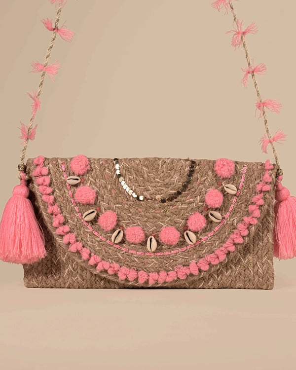 Handbag with pink pom-poms and tassels on a beige background