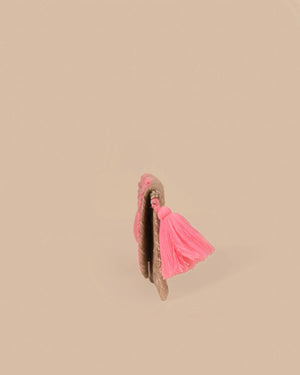 Moccasin shoe with pink tassel on a beige background