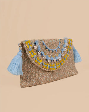 Woven clutch bag with blue and yellow accents and tassels on a beige background