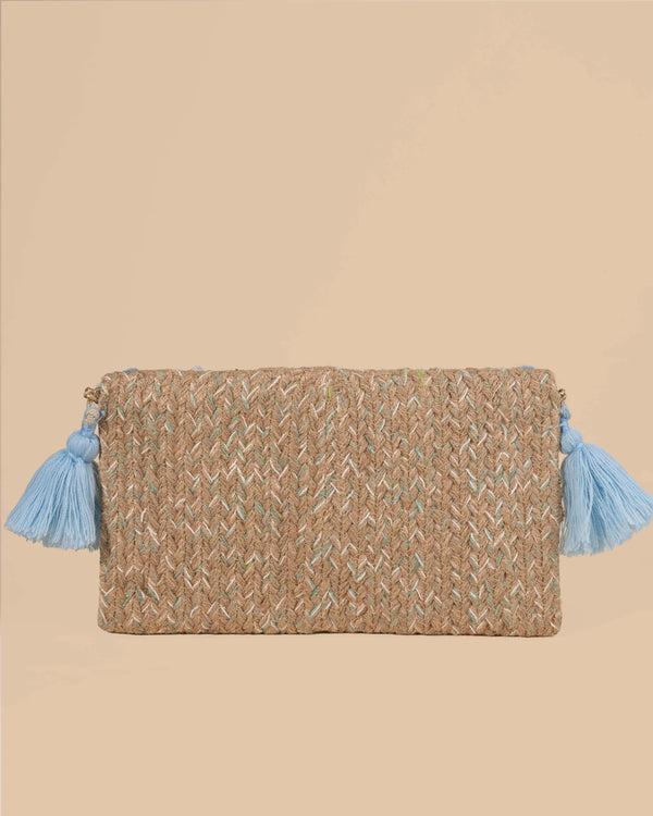 Woven clutch bag with blue tassels on a beige background